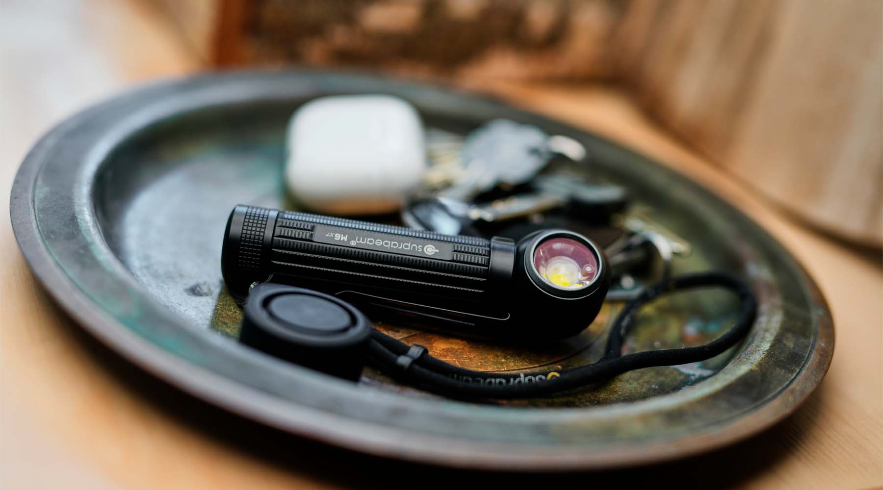 Suprabeam M6xr Lampe Eine Suprabeam M6xr BodyGuard Lampe liegt auf einer kleinen Metallablage.