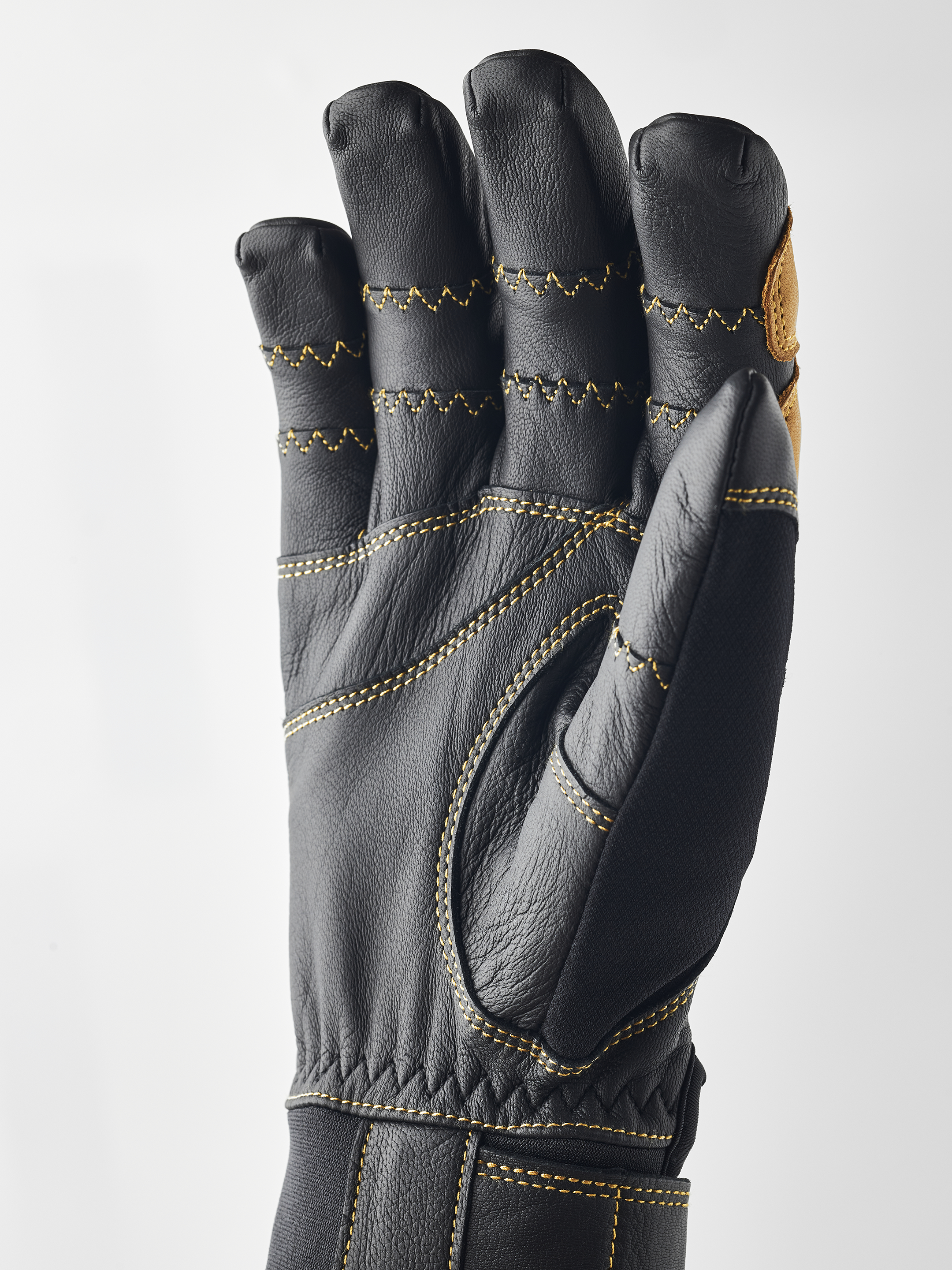 Schwarzer Hestra Handschuh Schwarzer Hestra Ergo Grip Active Handschuh, Handfläche nach vorn, gelbe Nähte.