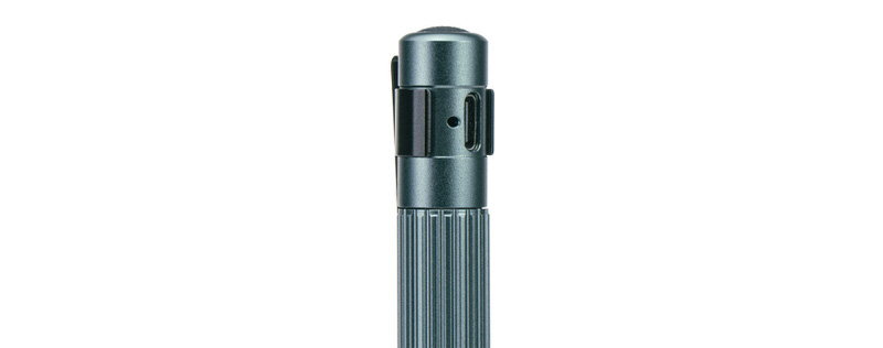 Suprabeam Q1r Stiftlampe Nahaufnahme der Suprabeam Q1r Stiftlampe in Anthrazit. USB-C Ladeanschluss und Befestigungsclip sichtbar. Geriffelte Grifffläche.