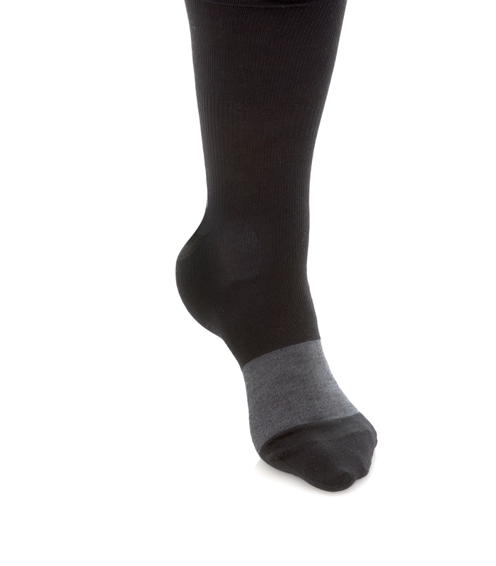 Schwarze Socke mit Graufuß Fuß mit schwarzer Socke, Knöchelbereich grau abgesetzt, isoliert auf weißem Hintergrund.