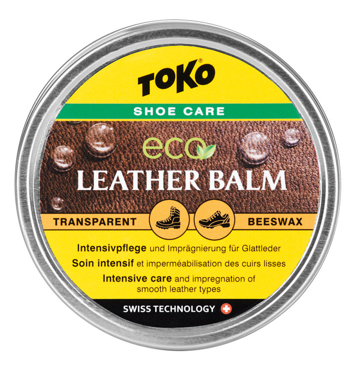 Dose Toko Eco Leather Balm mit gelbem Etikett und Lederhintergrund. Enthält Text und Piktogramme für Schuhpflege.