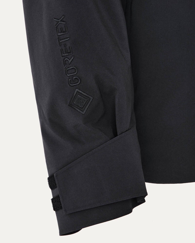 Ärmel der Gore-Tex Jacke Detailansicht vom Ärmel der schwarzen Gore-Tex Jacke mit Logo und Klettverschluss.