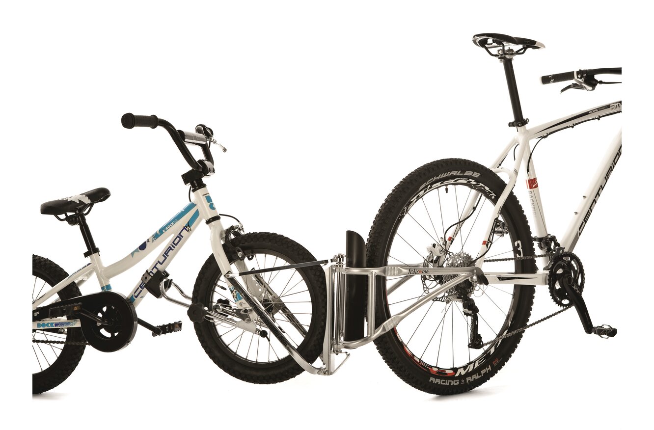 Erwachsenen- und Kinderfahrrad Ein weißes Erwachsenenfahrrad ist mit einer Tandemstange mit einem weißen Kinderfahrrad verbunden.