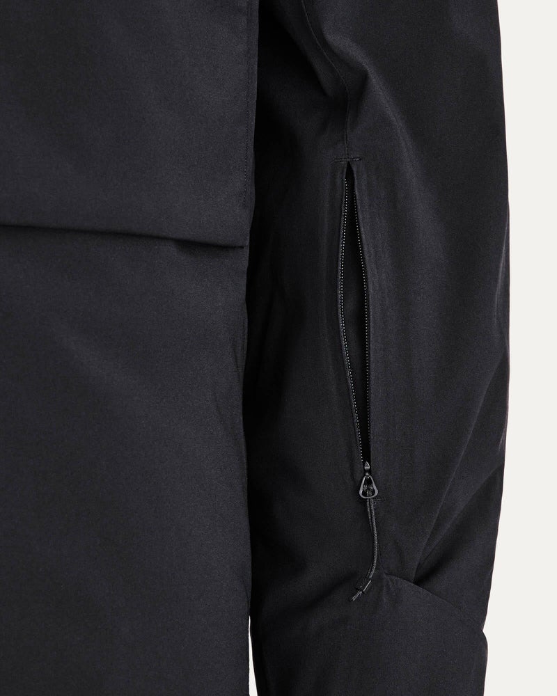 Schwarze Gore-Tex Jacke Detailaufnahme einer schwarzen Gore Tex 2L Stretch Jacke mit Reißverschlusstasche am Ärmel.