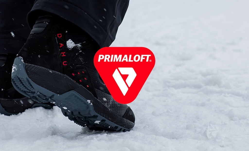 Schwarzer Dahu Skischuh Nahaufnahme eines schwarzen Dahu Skischuhs mit rotem Primaloft Logo im Schnee.