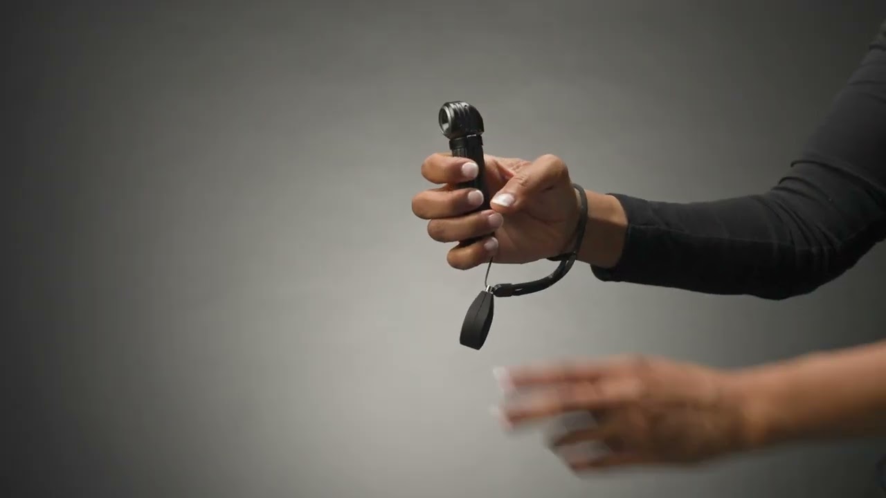 Suprabeam M6xr Taschenlampe Eine Hand hält die Suprabeam M6xr BodyGuard Taschenlampe. Am Handgelenk ist ein Trageband befestigt.