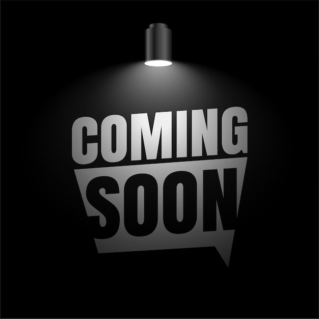 "Coming Soon" sous un projecteur dans un espace sombre.
