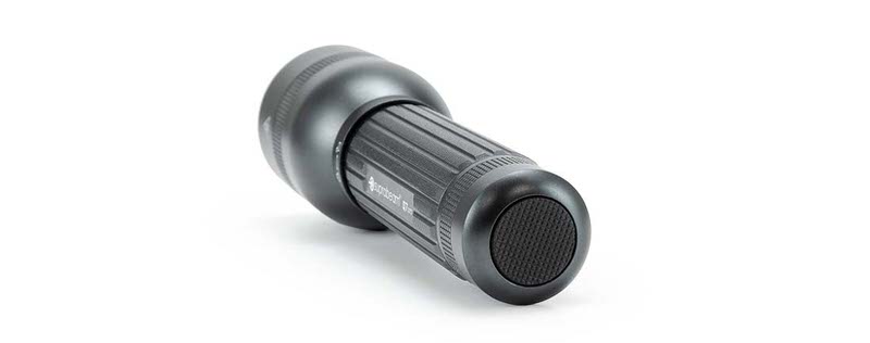 Lampe de poche LED noire Suprabeam Q7xrs, positionnée horizontalement, avec poignée striée et surface mate sur fond blanc.
