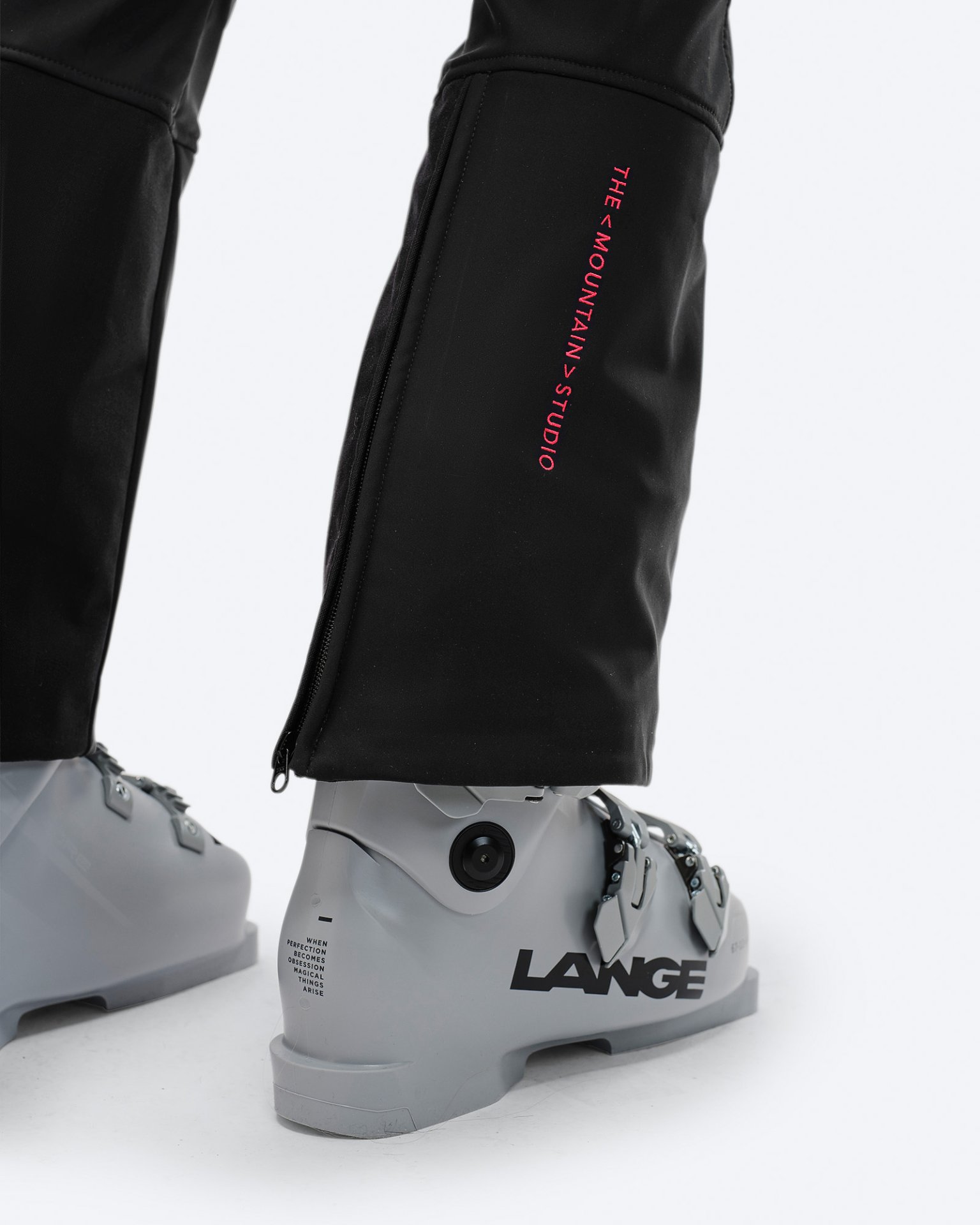 Schwarze P-4 W 2L Skihosen Detailaufnahme der schwarzen P-4 W 2L Stretch Ski Pants mit Ski-Schuh. Reißverschluss am Beinabschluss und Logo sichtbar.