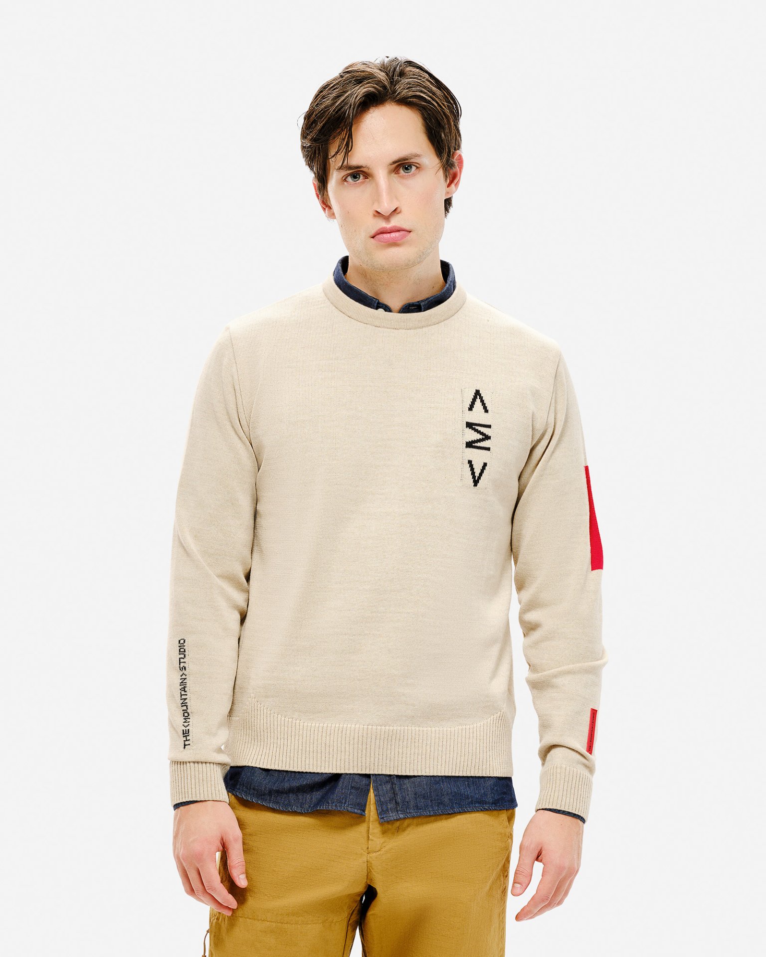 Heller K-3 ST Ski Sweater Mann trägt hellen K-3 ST Ski Sweater mit Rundhalsausschnitt, Logo und rotem Detail am Ärmel.