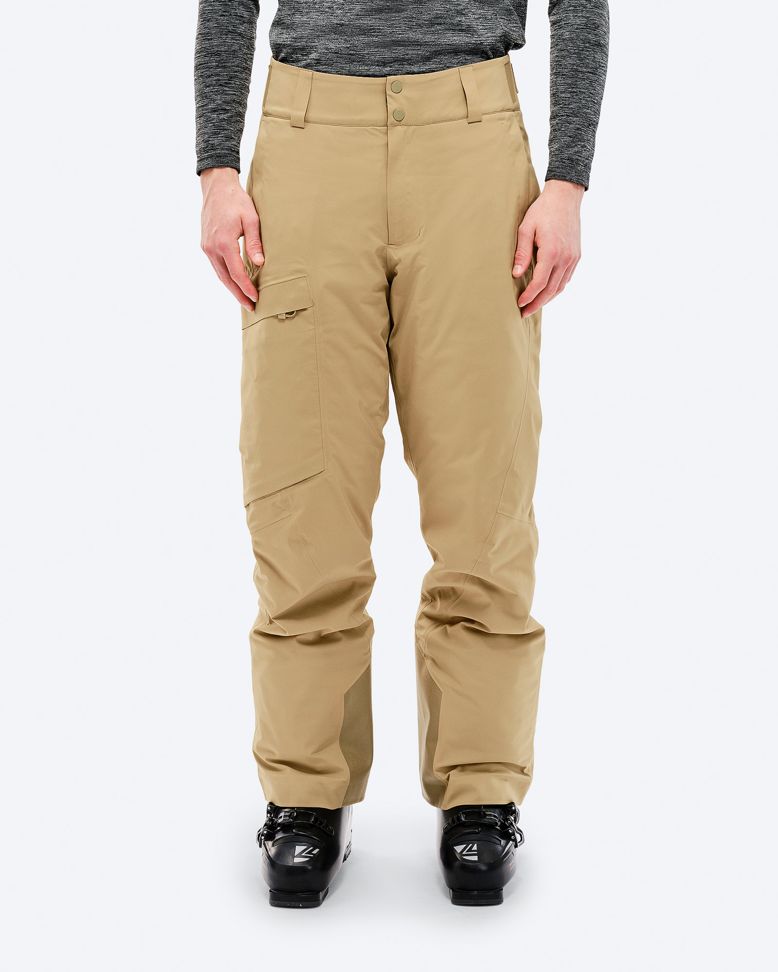 P-1 GORE-TEX Skihose Eine Person trägt eine Sandfarbene P-1 GORE-TEX 2L Stretch Insulated Skihose und Skischuhe vor einem weißen Hintergrund.
