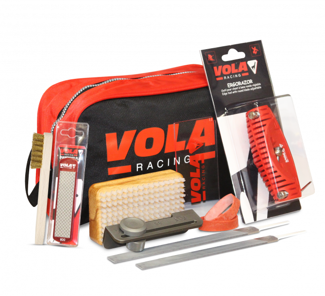 Vola Tuning Kit Plus: Werkzeuge wie Feile, Bürste, Kantenhobel und Schleifstein vor einer roten Tasche mit Vola Logo.