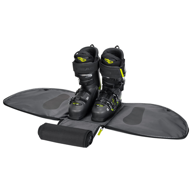 Head Skischuhe in geöffneter Bootbag Tasche. Die Tasche ist grau und die Skischuhe sind schwarz mit gelben Akzenten.