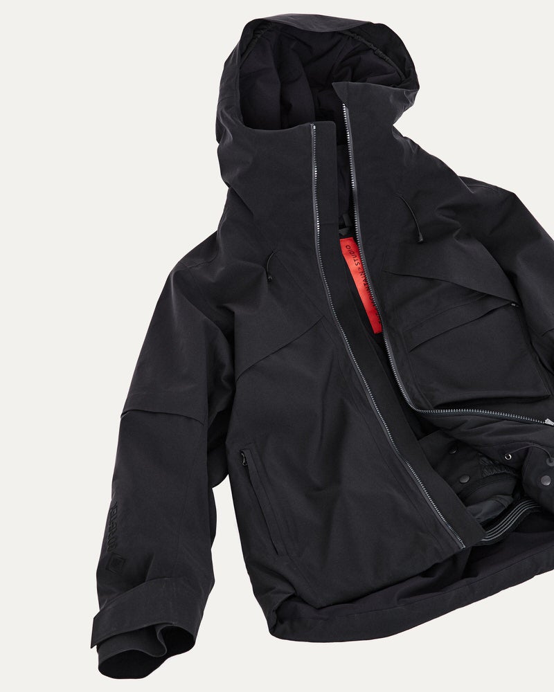Schwarze Gore-Tex Jacke Schwarze, offene S-1 Gore-Tex 2L Stretch Insulated Jacket mit Kapuze und Reißverschluss. Taschen und Details sichtbar.