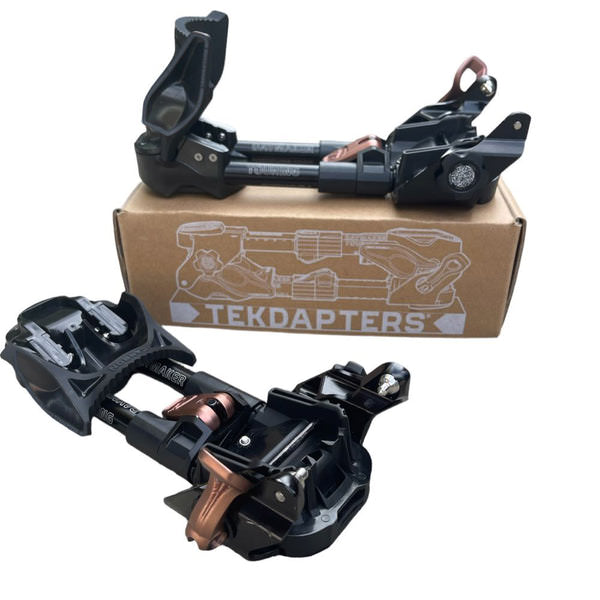 Zwei Daymaker Tekdapters Ski Touring Adapter vor einem Karton mit dem Tekdapters-Logo.