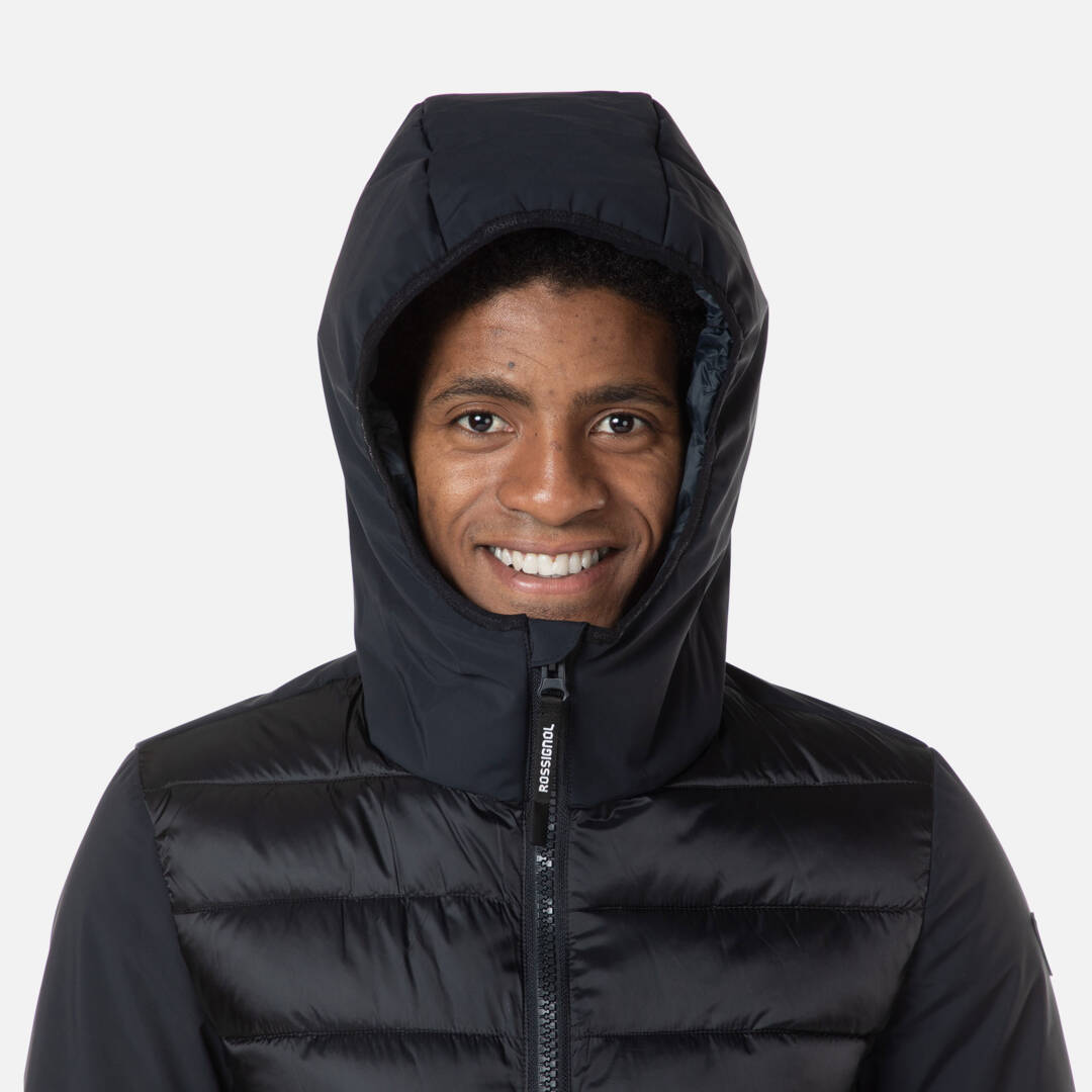 Lächelnder Mann in Hoodie Porträt eines lächelnden Mannes mit schwarzer, gesteppter Rossignol Stretch Quilt Hoodie JKT Kapuzenjacke.