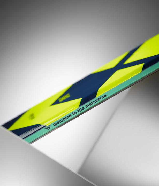 Black Crows Atris Skis Detailansicht Ski Black Crows Atris mit gelb-blauem Muster und dem Schriftzug "Welcome to the Metaverse".