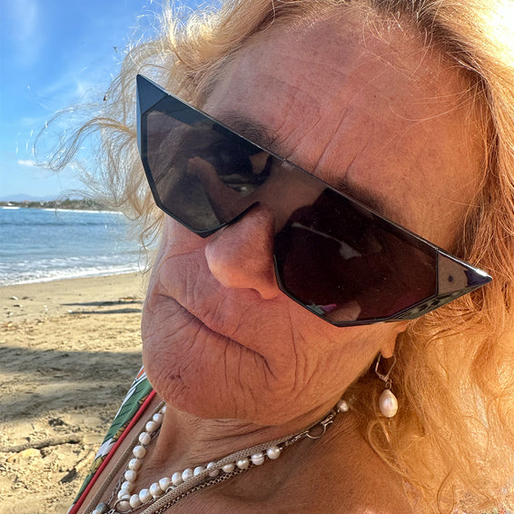 Gros plan sur une femme portant des lunettes de soleil Onyx à la plage.
