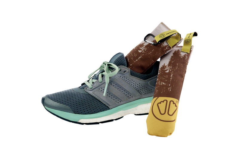 Grauer Laufschuh mit Sidas Cedar Wood Dryer Bag, mit Baum Muster, im Schuh.