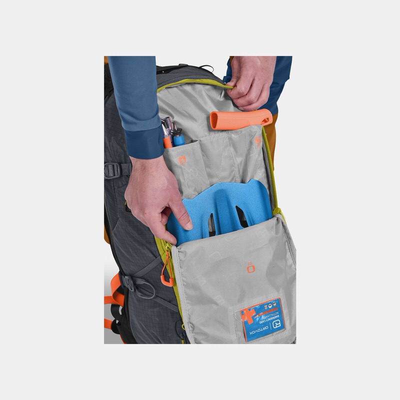 Ortovox Avabag Litric Rucksack Geöffneter Ortovox Avabag Litric Tour 30 Rucksack in Black Steel Farbe mit Skitouren Ausrüstung und blauer Helmhalterung.