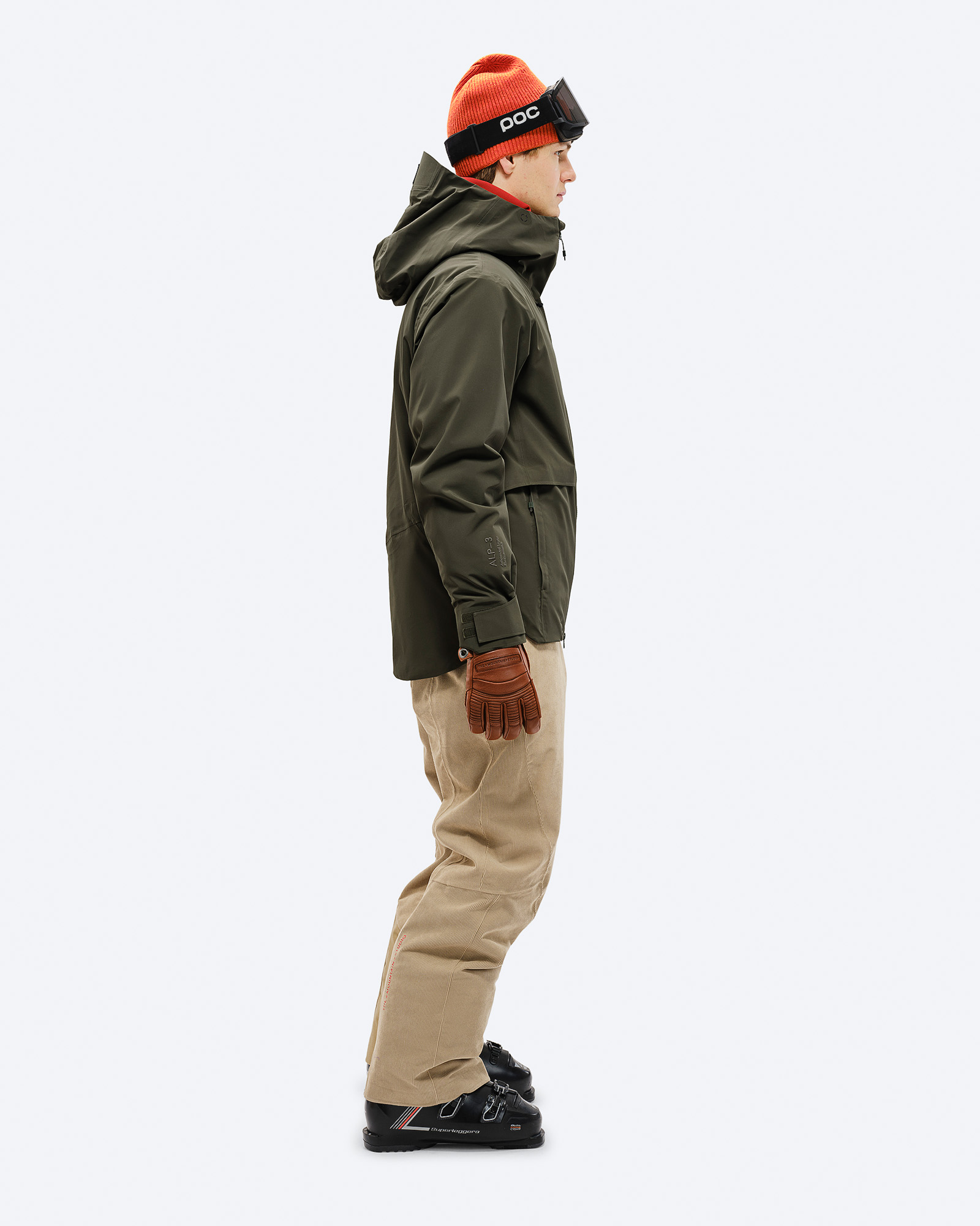 Skifahrer in grüner Jacke Ein Mann in seitlicher Ansicht, trägt eine grüne S-3 Carv Insulated Stretch Jacket, Skihose, Mütze und Skibrille.