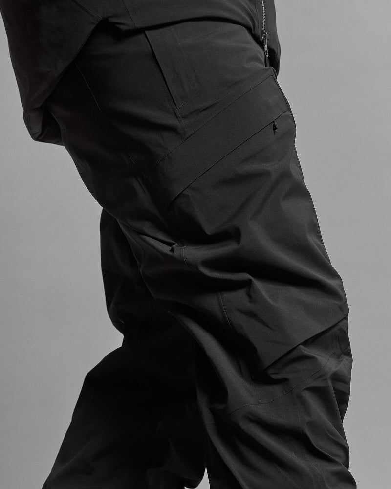 GORE-TEX Stretch Hose Detailaufnahme einer schwarzen, isolierten GORE-TEX Stretch Hose mit Tasche am Bein und Kniefalte.