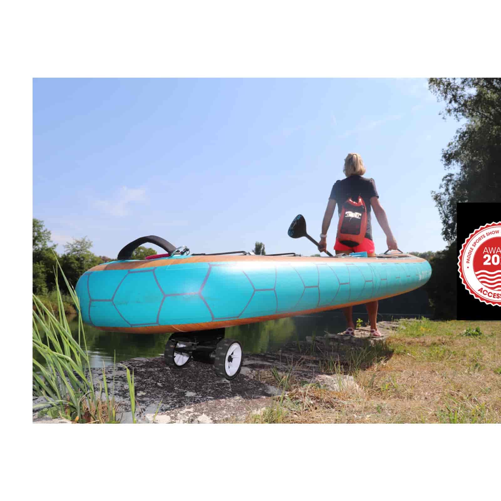 Blaues SUP Board mit Rädern Blaues SUP Board mit SUPmover Rädern, getragen von Person. Paddel wird gehalten.