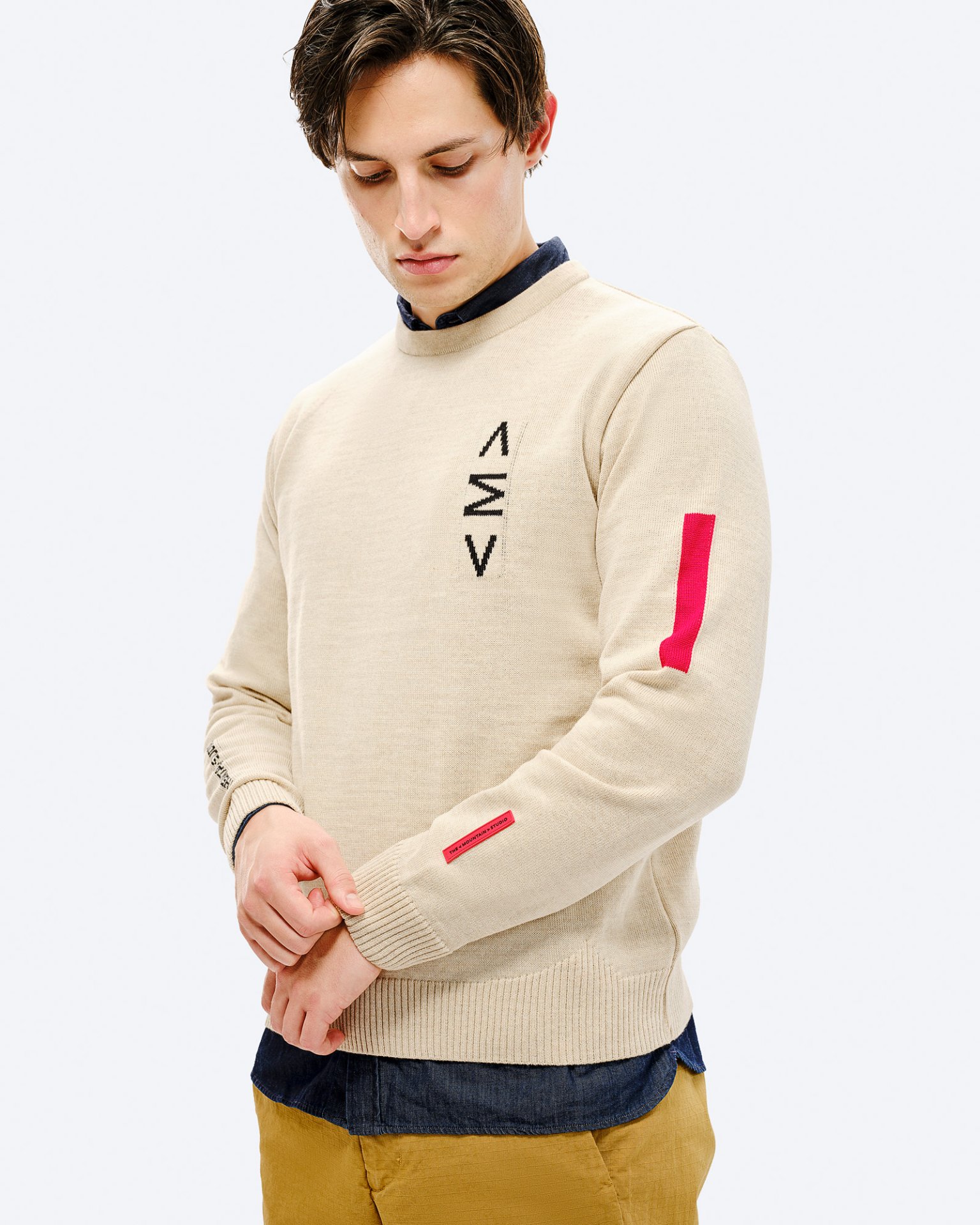 Ski Pullover St. Moritz Mann im Ski Sweater St. Moritz. Beiger Pullover mit rotem Detail am Ärmel und schwarzem Muster auf der Brust.