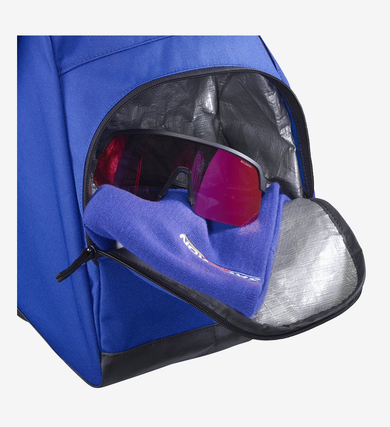 Blaue Skischuhtasche, offenes Fach mit Sonnenbrille auf blauem Tuch.