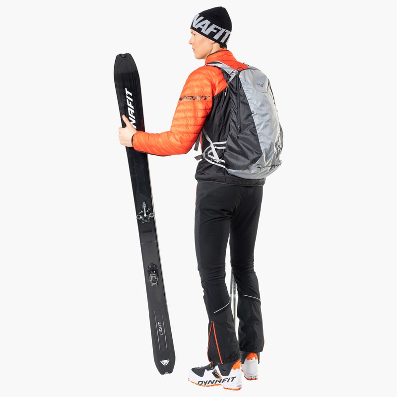 Dynafit Touren-Set Person mit Dynafit Ausrüstung hält Blacklight 95 Ski. Touren-Setup mit Rucksack und passender Bekleidung.