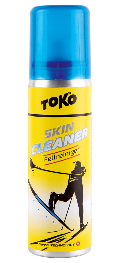 Gelbe Sprühflasche "Toko Skincleaner", blauer Deckel. Abbildung: Skilangläufer. Produkt für Fellreinigung.