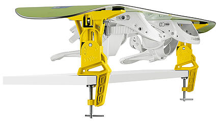 Gelber Toko Universal Adapter hält Snowboard auf Ski Vise Worldcup, montiert auf einer Werkbank.