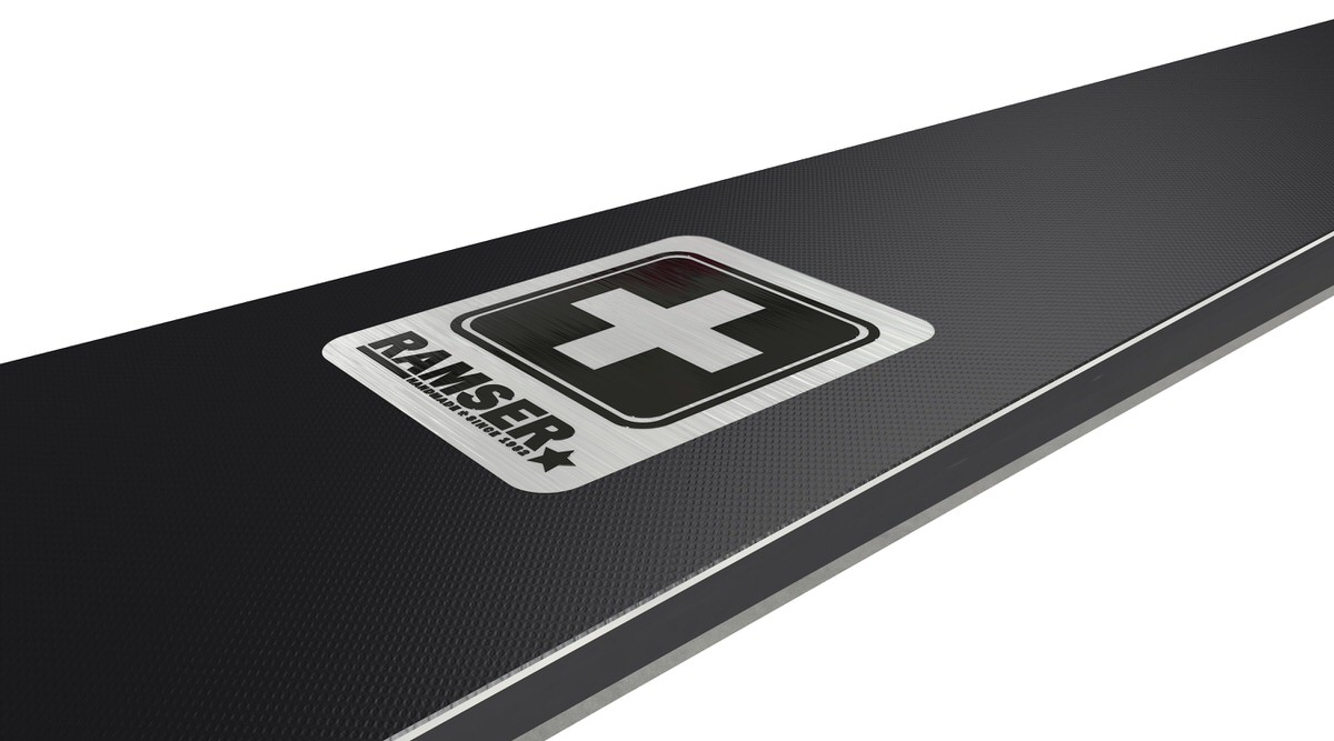 Ramser Black Detailaufnahme Detailaufnahme eines Ramser Black Produkts mit Logo und Schweizer Kreuz auf schwarzem, texturiertem Untergrund.