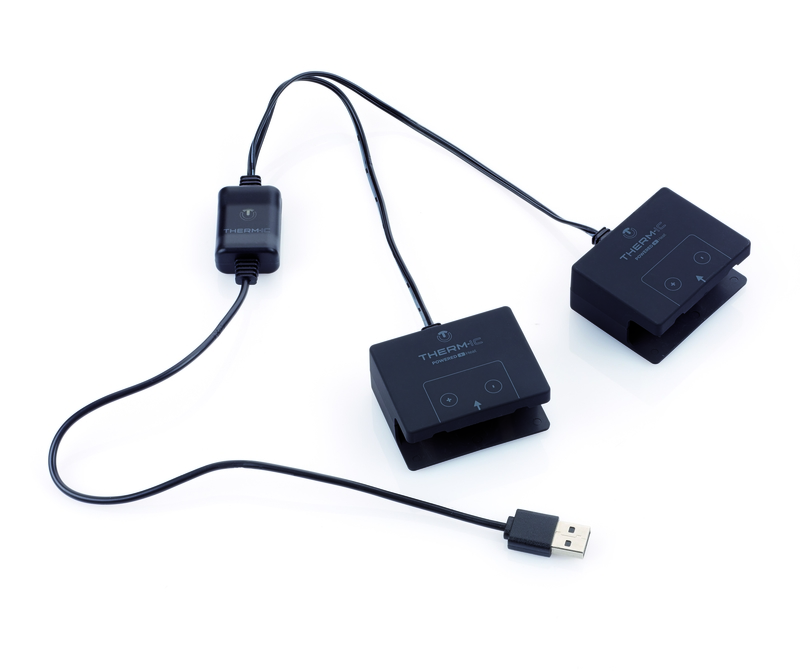 Schwarzes USB-Ladegerät mit Kabeln, die zu zwei S-Pack Akku-Clips führen. USB Stecker unten rechts.