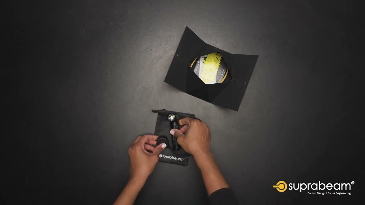 Suprabeam M6xr Lampe Die Suprabeam M6xr BodyGuard Lampe wird in ihrer Verpackung präsentiert. Hand packt die Lampe in einen Beutel.