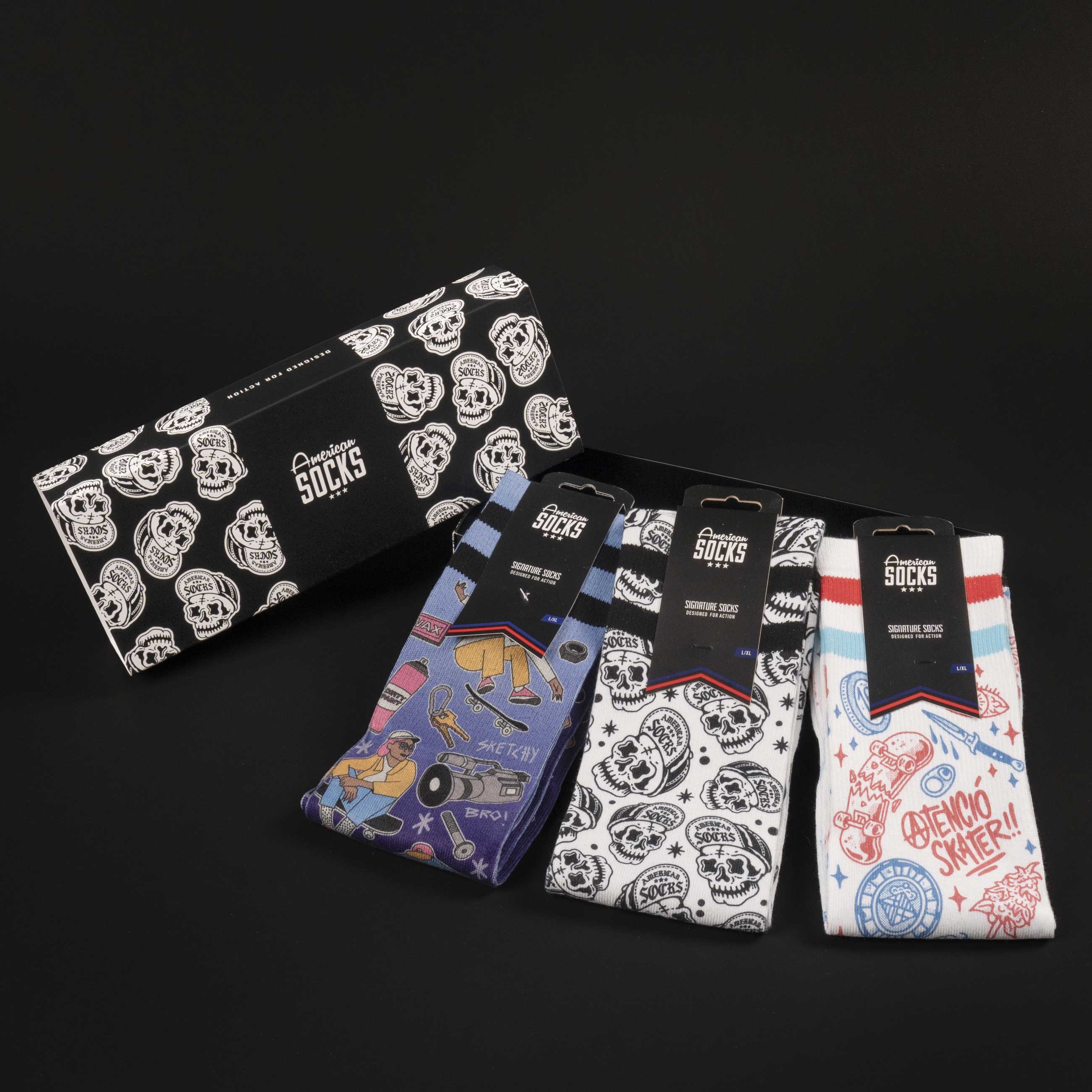 Boîte cadeau de chaussettes de skate Boîte cadeau avec des chaussettes de skateur dans différents designs, y compris des têtes de mort et des motifs de skateboard.