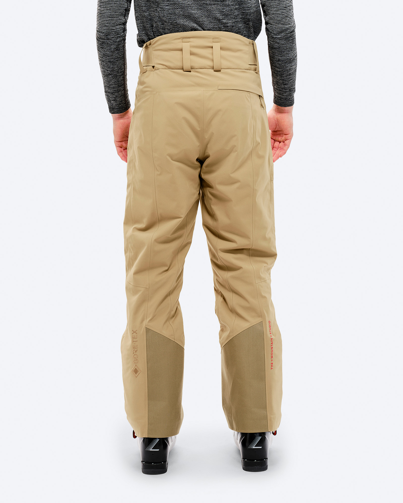P-1 GORE-TEX Skihose Rückansicht: Person trägt sandfarbene P-1 GORE-TEX 2L Stretch Insulated Pant, Skischuhe.