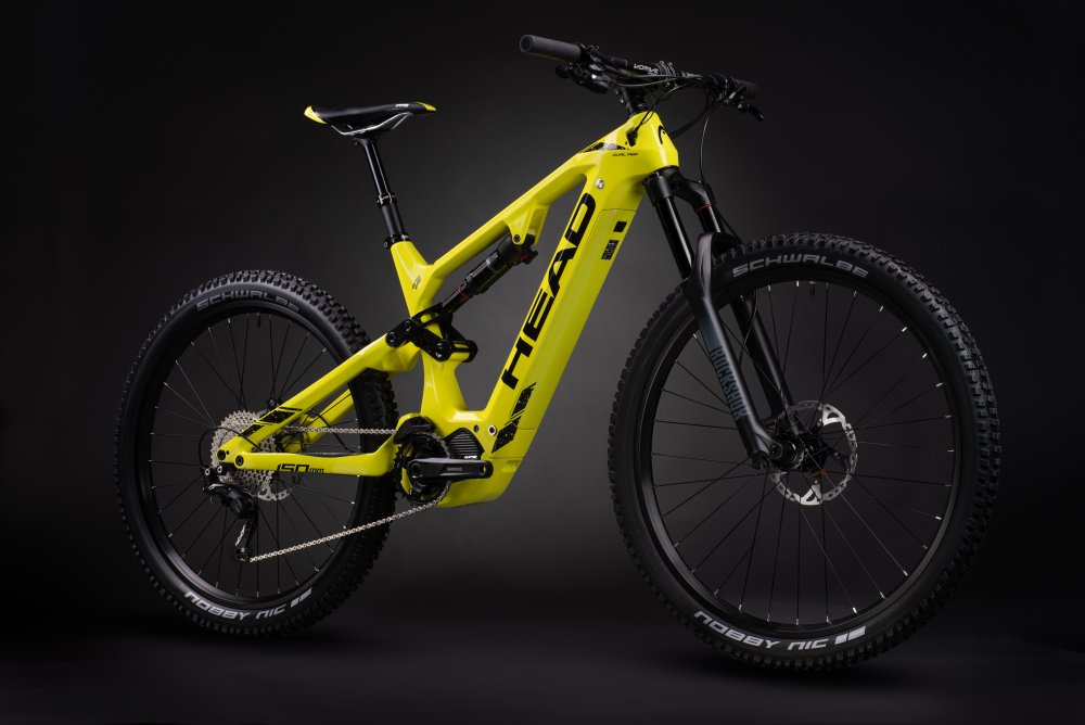 Gelbes Muret E-Mountainbike Gelbes Muret 2 EP8 E-Mountainbike mit Carbon-Rahmen und RockShox-Federung im Studio vor dunklem Hintergrund.