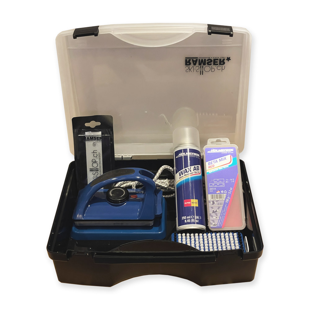 Geöffneter Koffer mit Holmenkol Beta Wax Set: Wachseisen, Wachs, Bürste, Wachsentferner-Spray und Plexiklinge.