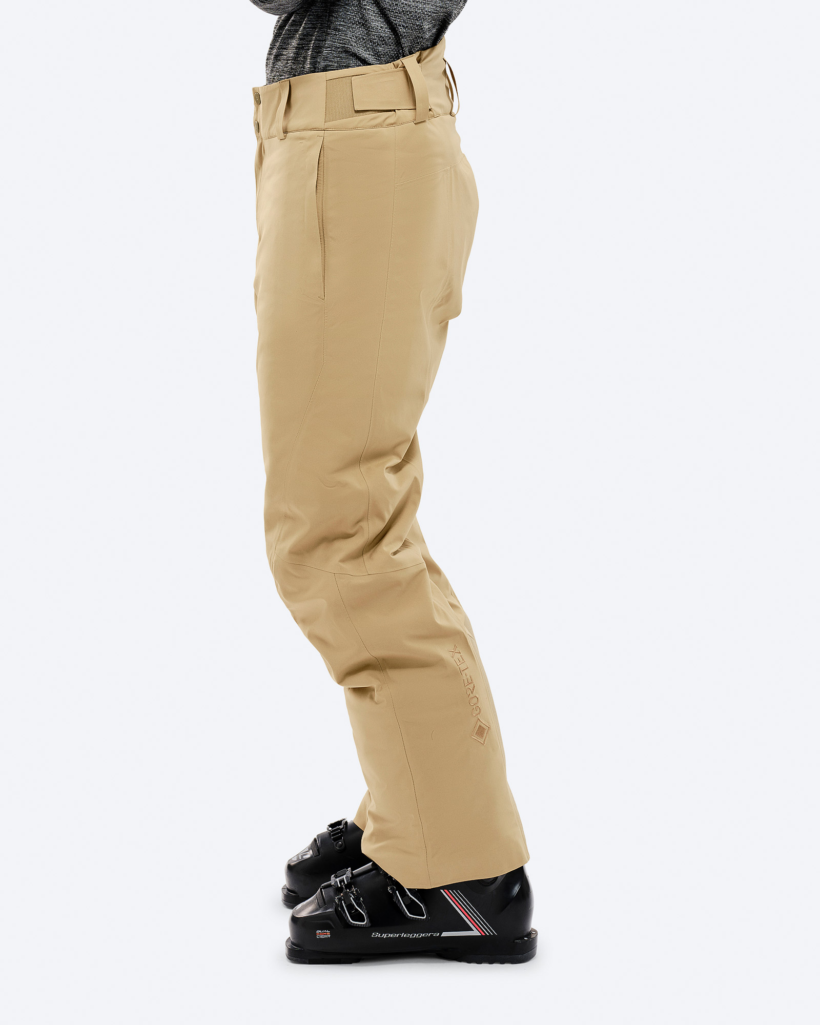 GORE-TEX Skihose Sandfarbe Sandfarbene P-1 GORE-TEX 2L Stretch Insulated Hose in Seitenansicht, getragen mit Skischuhen. Gore-Tex Logo sichtbar.
